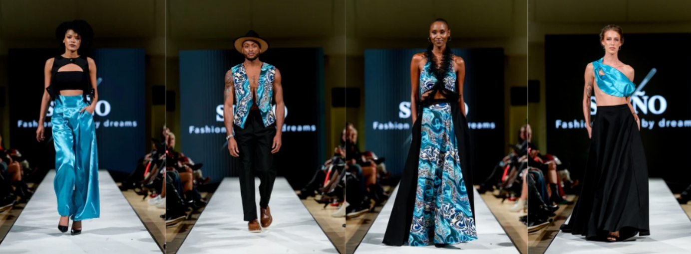 Four models walk a runway wearing vibrant blue and black outfits with bold patterns. The background features a screen with the text “SINO Fashion created by dreams.”.
